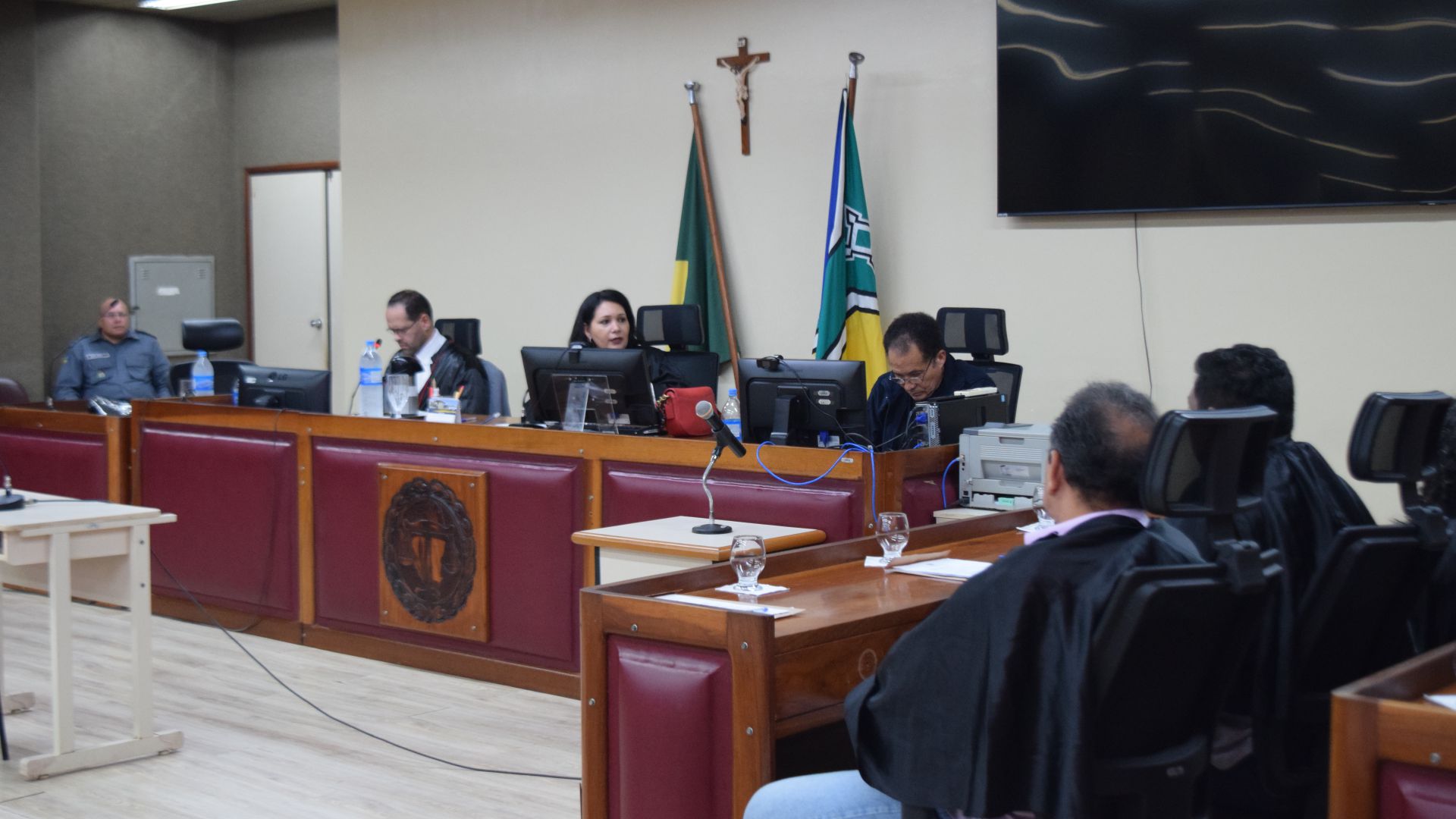 Na imagem, pessoas sentadas participando de julgamento, sendo uma delas a juíza Livia Freitas no fórum de Macapá